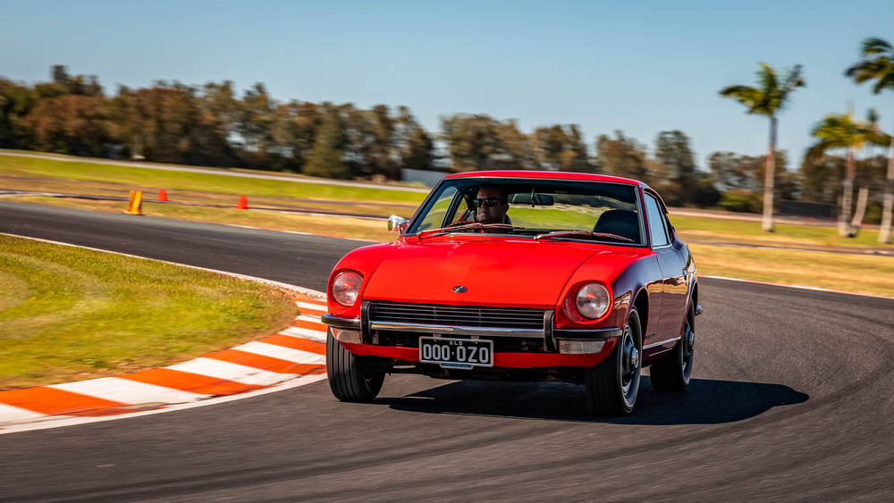 rouge vue de face roule sur un circuit et prend un virage
