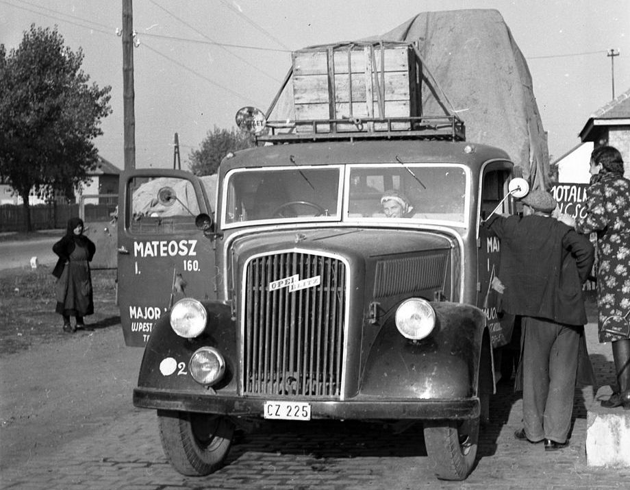 un Blitz de 1941 à l'arrêt, un couple à l'extérieur parle à une femme sur la place passager, la portière du conducteur est ouverte