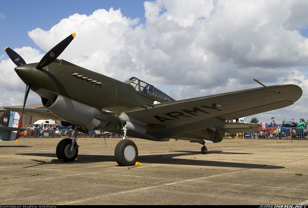 un Curtiss P-40B Warhawk au sol vu en contre-plongé de 3/4 avant gauche