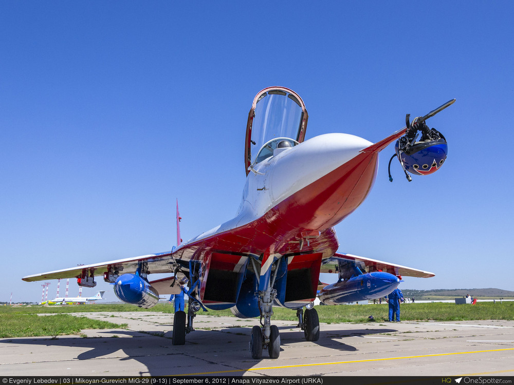 un MiG-29 9.13, verrière du cockpit ouverte, un casque est attaché sur le pic de l'avant de l'avion, vu à hauteur d'homme