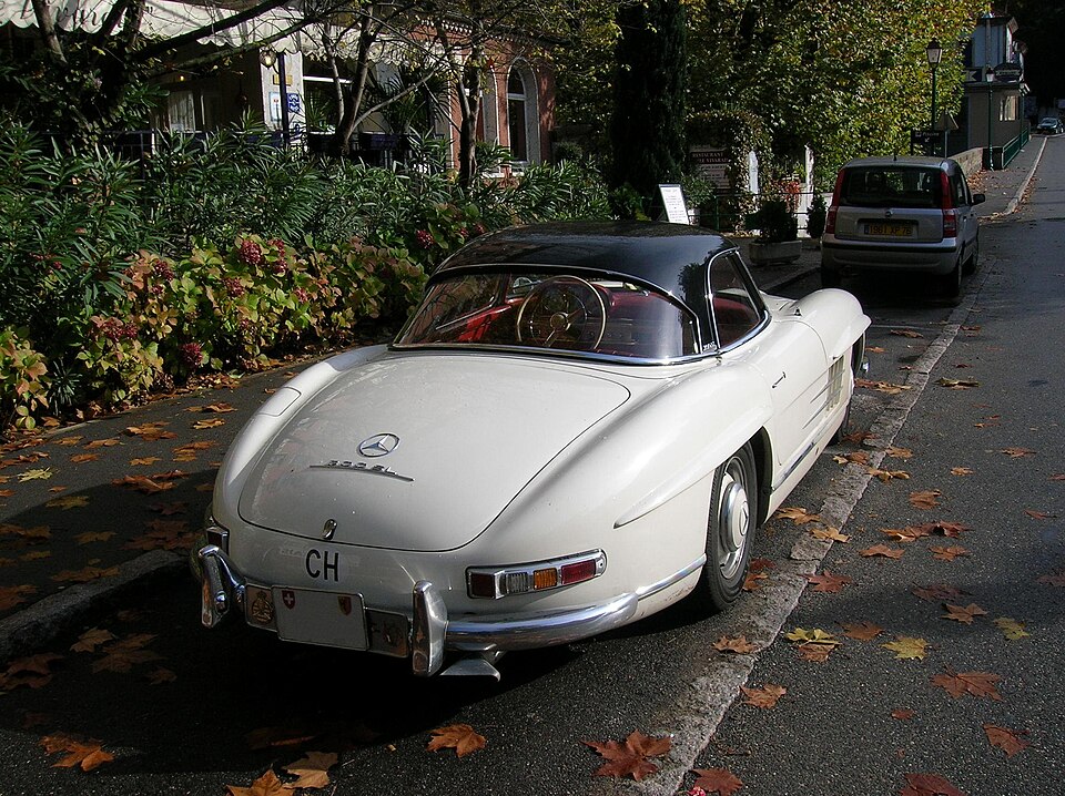 une Mercedes-Benz 300 SL roadster blanche à toit rigide vue de 3/4 arrière droit