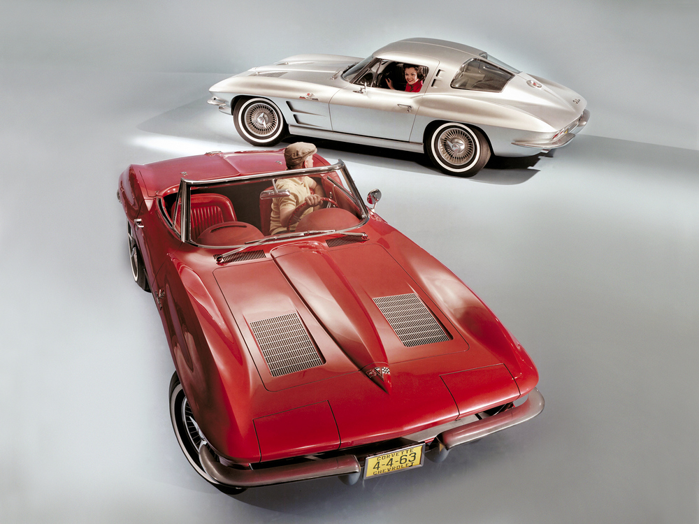 2 Chevrolet Corvette Sting Ray (0800) de 1963, l'une rouge vue de 3/4 avant droit légèrement aérienne, l'autre gris métallisé vue de profil gauche