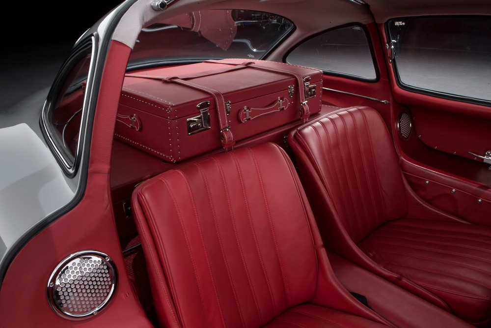 l'habitacle cuir rouge de la Mercedes-Benz 300 SL 1955 gris métallisé (vue sur les sièges, la planche arrière et la valise sur-mesure)
