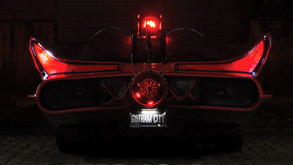 la Batmobile 1966 vue de l'arrière dans la pénombre, feux, réacteur et gyrophare allumés