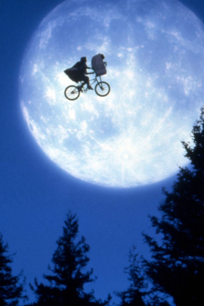 Elliott et E.T. en vélo volent devant la Lune