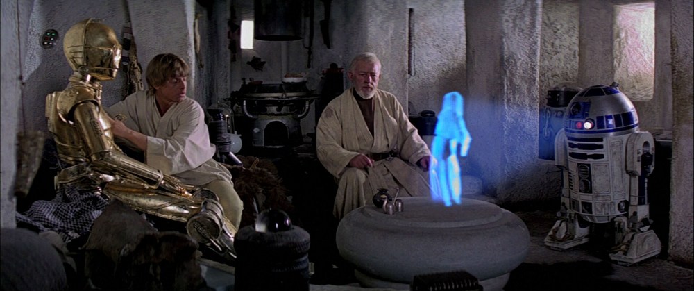 R2-D2 délivre le message de Leia à Obi-Wan Kenobi en présence de Luke et C-3PO