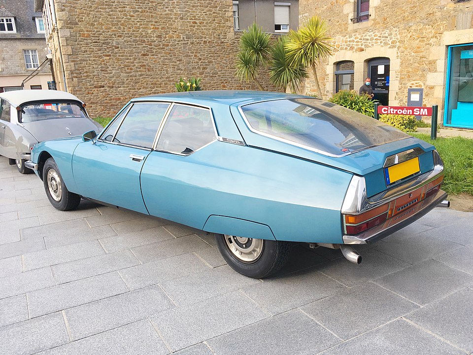 une Citroën SM (bleu platine) vue de 3/4 arrière gauche