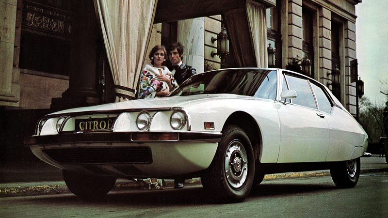 une Citroën SM (US-spec) 1973 vue de 3/4 avant gauche (vue du sol avec 2 modèles)
